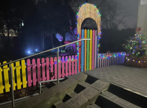 Kolorowy płot obwieszony kolorowymi lampkami.