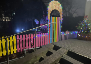 Kolorowy płot obwieszonych kolorowymi lampeczkami.