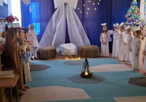 Grupa dzieci prezentuje przedstawienie jasełkowe przed emerytowanymi nauczycielkami i pracownikami przedszkkola.