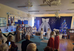 Grupa dzieci występuje przed Babciami i Dziadkami.