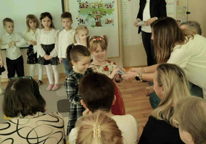 Dwie dziewczynki wręczają upominki Babciom i Dziadkom.