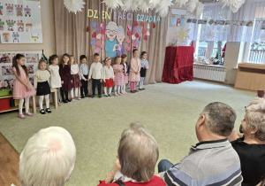 Grupa dzieci występuje przed Babciami i Dziadkami.
