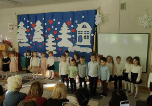 Grupa dzieci występuje przed Babciami i Dziadkami.
