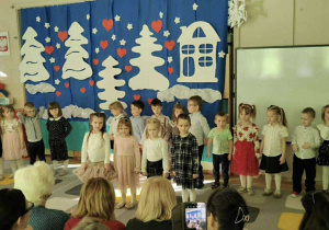 Grupa dzieci występuje przed Babciami i Dziadkami.