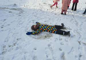 Grupa dzieci bawi się na śniegu.