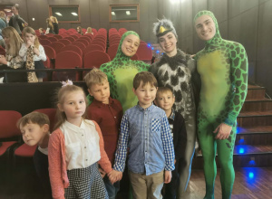 Do zdjęcia pozuje pięcioro dzieci wraz z a trzema aktorami przebranymi w strój żółwia (2 aktorów) i kukułki.