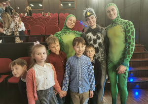 Do zdjęcia pozuje pięcioro dzieci wraz z a trzema aktorami przebranymi w strój żółwia (2 aktorów) i kukułki.