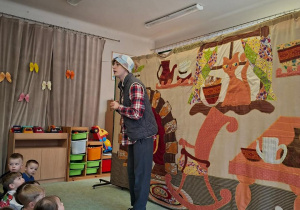 Aktor teatralny na tle scenografii.