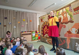 Aktorka teatralna na tle scenografii.