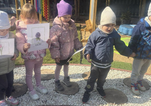 Dzieci wypatrują w ogrodzie pierwszych roślin