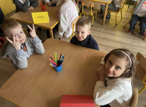 Troje dzieci czeka na rozpoczęcie konkursu.