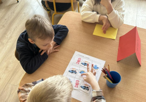 Troje dzieci podczas rozwiązywania zadania konkursowego.