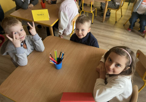 Troje dzieci czeka na rozpoczęcie konkursu.