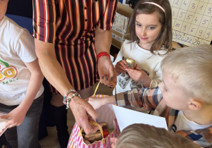 Dzieci częstują się czekoladowymi zajączkami.