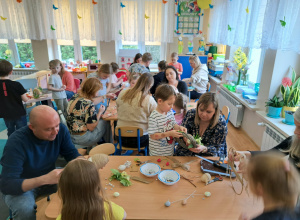 Dzieci i rodzice wykonują wielkanocne ozdoby.