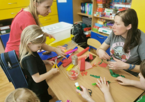 Dzieci i rodzice wykonują wielkanocne ozdoby.