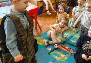 Chłopiec w kamizelce wojskowej.