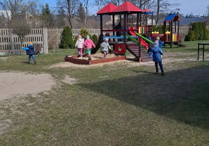 Dzieci poszukują cukierków na placu zabaw.