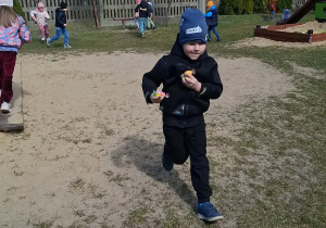 Dzieci poszukują cukierków na placu zabaw.