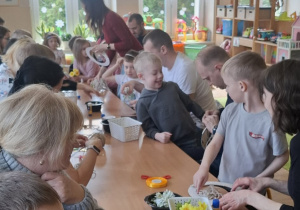 Dzieci wraz z rodzicami wykonują wianki wielkanocne.