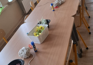 Stoły, na których przygotowane są materiały i ozdoby potrzebne do wykonania wianków wielkanocnych.