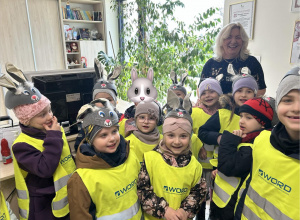 Dzieci (w czapeczkach zajączków) pozują do zdjęcia z Panią Naczelnik Wydziału Edukacji, Kultury i Sportu.