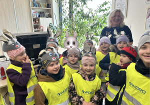 Dzieci (w czapeczkach zajączków) pozują do zdjęcia z Panią Naczelnik Wydziału Edukacji, Kultury i Sportu.