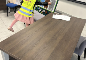 Dziewczynka przyporządkowuje ilustracje odpadów do odpowiednich miejsc na planszy.