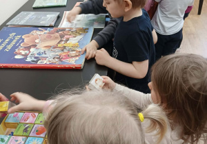 Chłopcy i dziewczynki oglądają obrazki w książkach