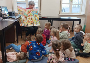 Grupa Żabek ogląda dużą książkę