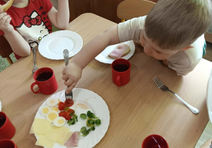 Dzieci wspólnie jedzą śniadanie przy stole