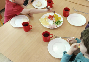 Chłopiec sięga po pomidorka koktajlowego