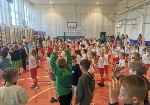 Dzieci – reprezentacje przedszkoli podczas rozgrzewki w hali sportowej .