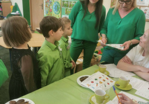 Trzyosobowa grupa dzieci (reprezentacja przedszkola) objaśnia konkursowe zadanie komisji turniejowej i prowadzącym konkurs.