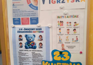 Tablica informacyjna o Niebieskich Igrzyskach w przedszkolu oraz fakty dotyczące spektrum autyzmu.