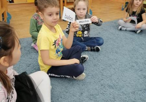 Dzieci trzymają karki z wyrazami do globalnego czytania.