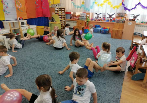 Dzieci uczestniczą w zajęciach gimnastycznych z balonami.