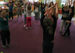 Dzieci tańczą w parach, wykonują ruch rękoma nad głową