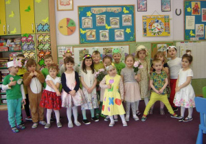 Grupa dzieci mająca ubrania w kolorach wiosennych i elementy/symbole wiosny.