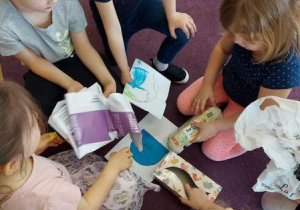 Grupa dzieci segreguje odpady papierowe.