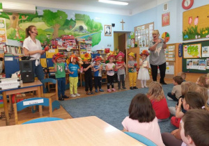 Dzieci w kolorowych kapeluszach grają na różnych instrumentach