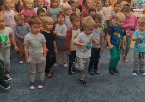 Grupa dzieci tańczy przy piosenkach o jesieni.