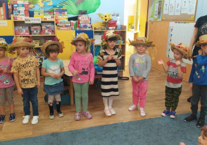 Siedmioro dzieci stoi w jesiennych kapeluszach.