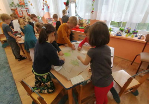 W zespołach, na szarym papierze dzieci projektują spódnice dla pani Jesieni.