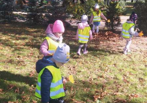 Dzieci w parku zbierają kolorowe liście.