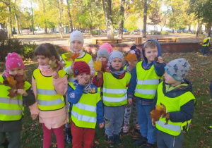 Dzieci w rękach trzymają bukiety z liśći.
