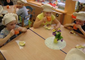 Dzieci piją wykonany przez siebie sok z marchwi.