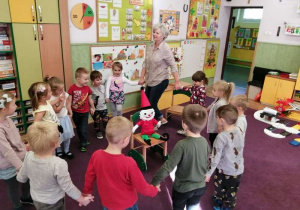 Dzieci w kole śpiewają piosenkę dla krasnala.
