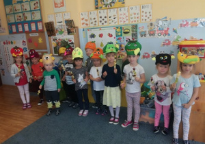 Zdjęcie grupowe – dzieci mają na głowach kolorowe owocowe czapeczki w rękach trzymają wykonane owocowe szaszłyki
