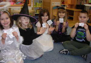 Pięcioro przebranych dzieci (Aniołek, dwie Czarodziejki, Pani Zima i Żółw Ninja) trzymają karteczki z obrazkami.